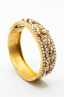 A SEED PEARL AND DIAMOND BANGLE, the pierced detail mount of leaf design se