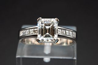 A DIAMOND AND WHITE GOLD RING, the rectangular cut diamond claw set between