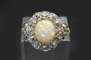 AN OPAL AND DIAMOND RING, the round cut opal set within a scalloped edge su