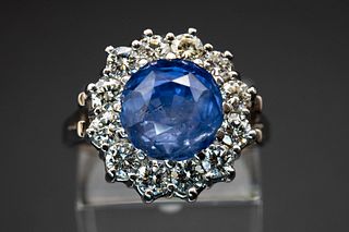 A CEYLON SAPPHIRE AND DIAMOND RING, the large round cut faceted sapphire se