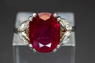 A RUBY AND DIAMOND RING, the oval cut ruby set between leaf shaped shoulder