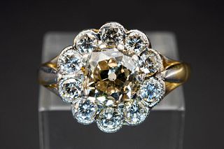 A DIAMOND CLUSTER RING, the central brilliant cut diamond set within a surr