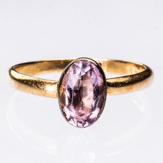 AN 18CT YELLOW GOLD AND PINK STONE RING, the oval cut pale pink stone set i