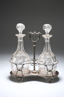 A PAIR OF EDWARDIAN CUT-GLASS DECANTERS IN A SILVER-PLATED STAND, the decan