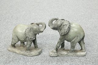 A PAIR OF CARVED STONE MODELS OF ELEPHANTS, each modelled with trunk raised