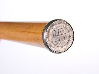 A MALACCA CANE, topped with a white-metal roundel with Swastika and date 19
