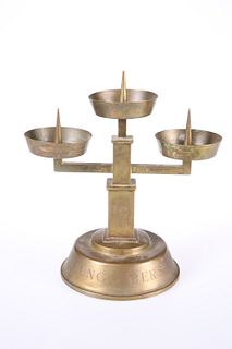 A BRASS PRICKET STICK, with three circular candle stands, bears engraved Na