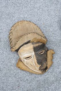 TRIBAL: A MASK, carved with off-set mouth and twisted nose, black and white