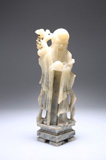 A CHINESE SOAPSTONE FIGURE, 19TH CENTURY, of an Immortal, carved standing h