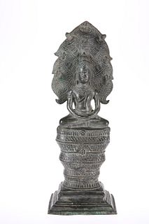 A CAMBODIAN BRONZE BUDDHA, seated with Naga, 18th Century. 33.5cm