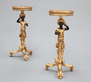 A PAIR OF BLACKAMOOR FIGURAL STANDS, each circular top with leaf moulded ed