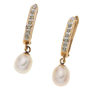 Par de aretes con perlas y simulantes en oro amarillo de 14k. 2 perlas cultivadas color crema forma oval. Peso:  1.7 g.