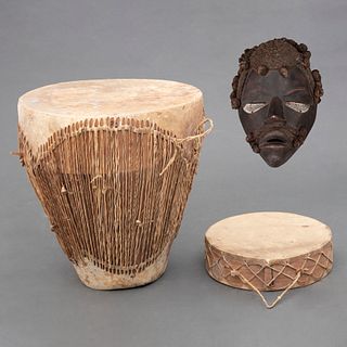 Juego de tambores y máscara. África, Siglo XX. Elaborados en cuero y fibra natural. Consta de: Tambor de piso. Pz: 3
