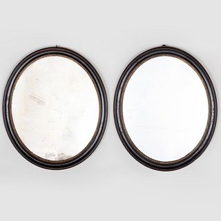Pair of  Small English Ebonized and Parcel-Gilt Oval Mirrors