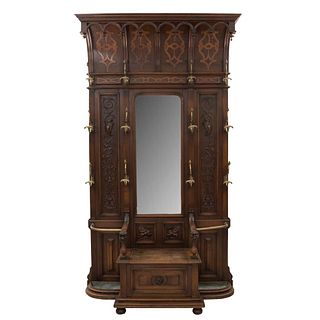 Perchero-paragüero. Francia. SXX. Estilo Enrique II. En talla de madera de nogal. Con 12 ganchos, espejo y asiento. 253 x 140 x 43 cm.
