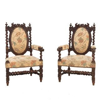 Par de sillones. Francia. Siglo XX. En talla de madera de roble. Con respaldos cerrados y asientos acojinados en tapicería beige.