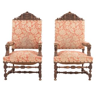 Par de sillones. Francia. SXX. Estilo Enrique II. En talla de madera de nogal. Con respaldos cerrados y asientos en tapicería floral.