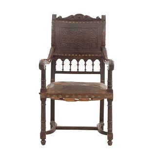 Sillón. Francia. Siglo XX. En talla de madera de roble. Con respaldo y asiento de piel color marrón.