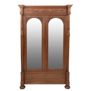 Armario. Francia. Siglo XX. Estilo Enrique II. En talla de madera de nogal. Con cajón y 2 puertas con espejos. 225 x 143 x 54 cm.