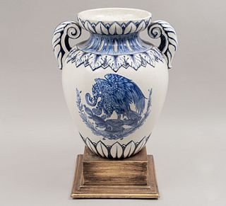 Jardinera. México, años 50. Elaborado en cerámica vidriada con emblemas nacionales en azul cobalto con base de madera escalonada.