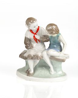 A SOVIET PORCELAIN FIGURAL GROUP OF A PAIR OF GIRLS ON A BENCH, ARTEL CERAMIC OR GORODNITSKY PORCELAIN FACTORY, CIRCA 1950S