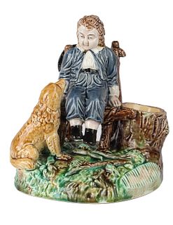 A RUSSIAN PORCELAIN INKWELL IN THE FORM OF A SITTING BOY WITH A DOG, KUZNETSOV PORCELAIN FACTORY, MOSCOW, 19TH CENTURY