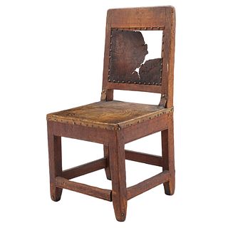 SILLA. SIGLO XIX.  Elaborada en madera de encino, asiento y respaldo de cuero, chambrana rectangular, con iniciales "TC".