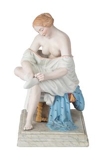 A RUSSIAN PORCELAIN FIGURE OF A WOMAN ADJUSTING HER HOISERY, GARDNER PORCELAIN FACTORY, MOSCOW, 1870-1890S