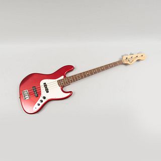 Bajo eléctrico. Estados Unidos. Siglo XXI. Marca Squier by Fender. Elaborado en madera tallada y policromada. Color rojo. Con funda.