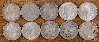Ten Morgan silver dollars of various dates and conditions, 1884-1921.