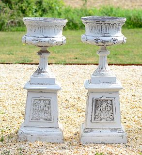 TWO LARGE PAINTED METAL URNS ON STANDS
