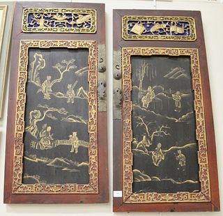 Pair of Chinese carved wood wall hangings with gold painted scenes, 40 1/2" x 19".
