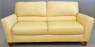 Leather sofa, two seats, pale yellow leather, along with pair of shag pillows, 78" lg. Provenance: The Estate of Andrew Wolf, New Haven, CT, Arts Chie