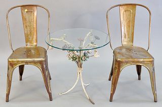Three piece lot to include glass top table with metal flower base, 23 1/2' h. x 24" diam. and two industrial metal chairs.