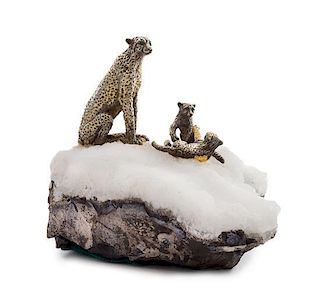 A Continental Silver Model of a Snow Leopard and Two Cubs, , each with emerald-inset eyes, modeled on a naturalistic calcite bas