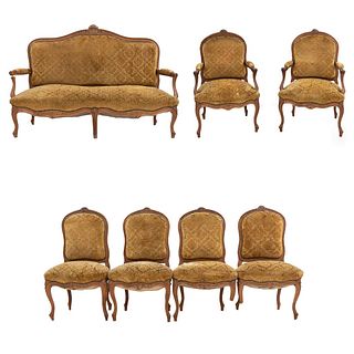 Sala. Francia. Siglo XX. Estilo Luis XV. En talla de madera de nogal. Consta de: par de sillones, 4 sillas y loveseat. Piezas: 7.