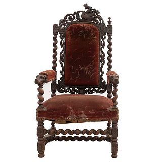 Sillón. Francia. Siglo XX. Estilo Enrique II. En talla de madera de roble. Con respaldo cerrado y asiento en tapicería color shedrón.