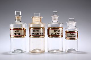 FOUR LATE VICTORIAN CLEAR GLASS LUG APOTHECARY BOTTLES, each with recessed 