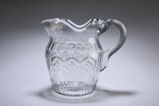 AN IRISH GLASS WATER JUG, CIRCA 1820, with deep scalloped rim and panel-cut