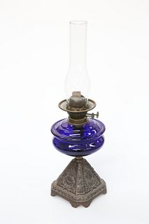 A QUEEN VICTORIA BLUE GLASS AND CAST IRON OIL LAMP, the base cast to two si