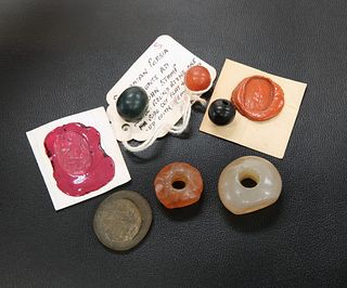 FOUR ROMAN INTAGLIOS, together with A GLASS SEAL AND A DRILLED BEAD. (6)