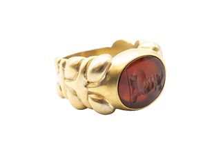 A CARNELIAN SIGNET RING
 The oval carnelian plaque featuring a carved intag