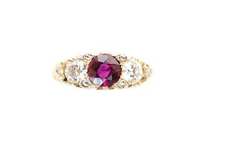 A RUBY AND DIAMOND THREE-STONE RING
 Set with a circular-cut ruby, flanked 