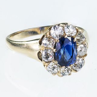 AN 18CT YELLOW GOLD SAPPHIRE AND DIAMOND CLUSTER RING
 The oval cut sapphir