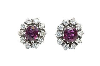 A PAIR OF RUBY AND DIAMOND CLUSTER EARRINGS
 The claw-set cushion-shaped ru