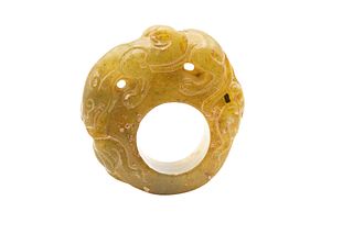 A CHINESE NEPHRITE JADE OFFICIAL'S THUMB RING, carved with dragon. 5cm diam