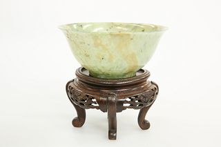 A CHINESE MOTTLED JADE BOWL, with everted rim, in grey/green stone with dar