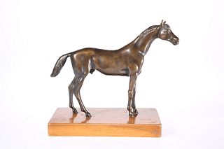 A BRONZE MODEL OF A HORSE, cast standing with tail raised and ears pricked,