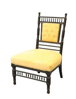 AN ARTS AND CRAFTS EBONISED NURSING CHAIR, with spindle gallery and turned 