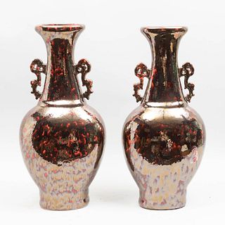 Par de jarrones. Origen oriental. Siglo XX. En cerámica vidriada color rojo. Acabado metálico. Asas orgánicas. 60 x 28 x 16 cm.